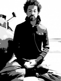 Paul Lara with a black jacket and beard in a meditation stance; Eyes closed.